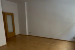leeres Zimmer mit weißen Wänden und Echtholzboden- Blick zur Zimmertür